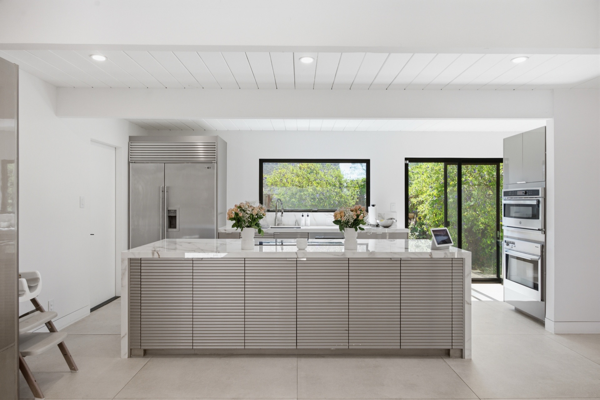 Chef's kitchen with Calacata quartz waterfall island and Sub-Zero refrigerator