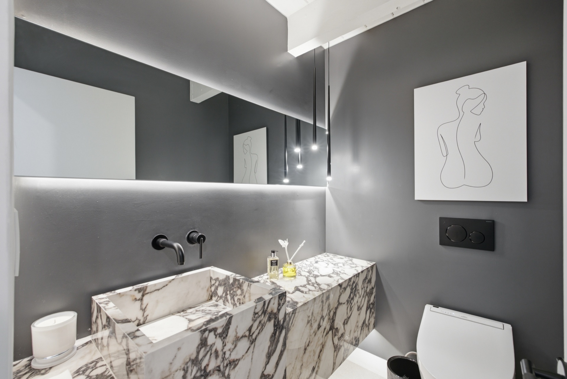 Powder room with sculptural Calacata marble vanity